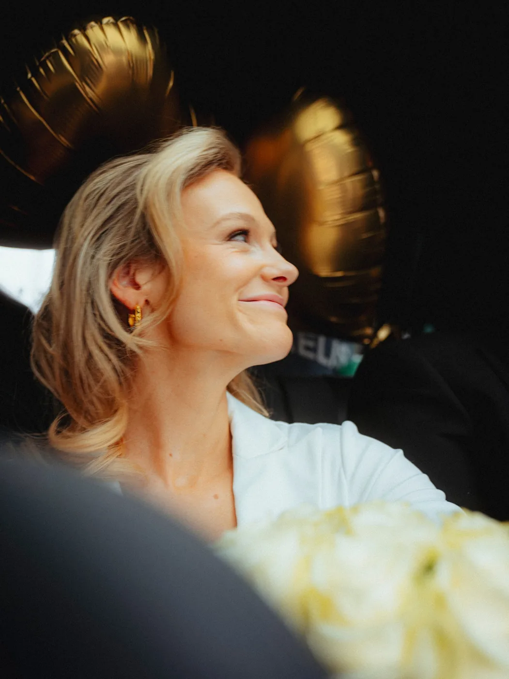 Braut lacht im Hochzeitsauto